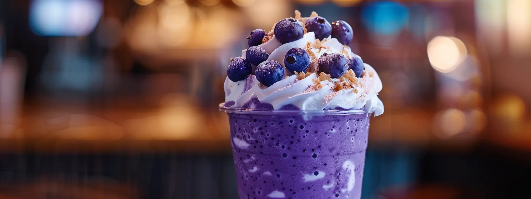 a vibrant blueberry muffin frappuccino topped with creamy whipped cream and a sprinkle of fresh blueberries, showcasing customization and delicious indulgence.